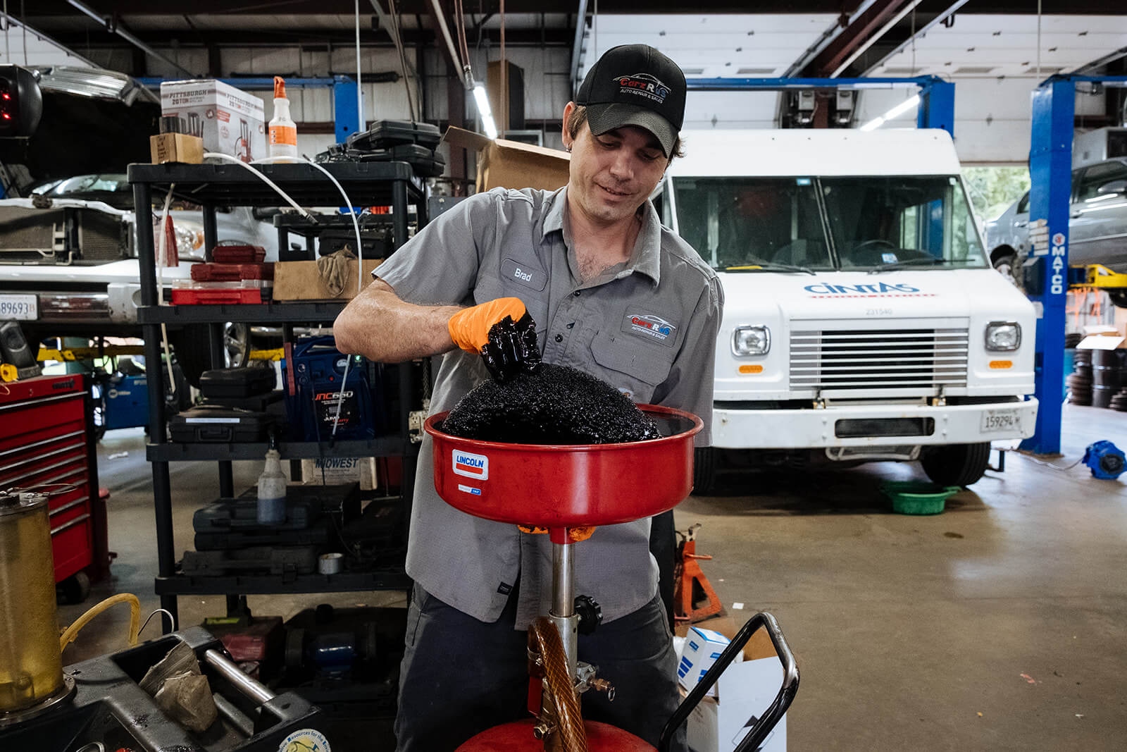 Fleet mechanic performing oil change service on commercial delivery van — Road Runner Fleet Services, Houston TX