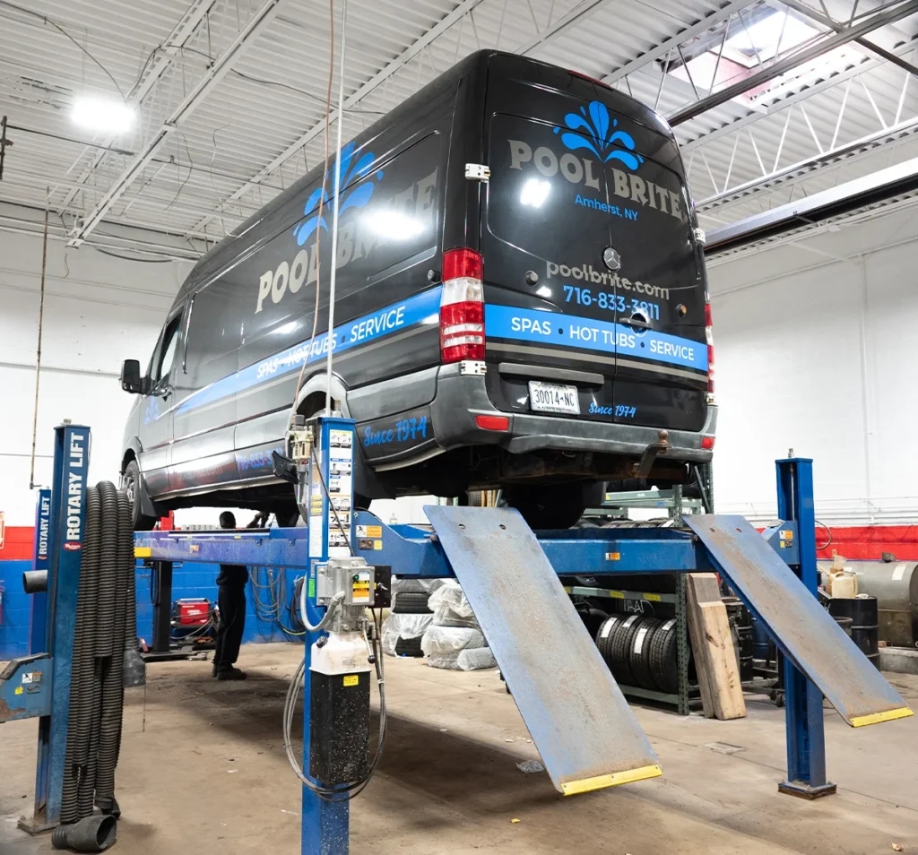 Commercial sprinter van on rotary lift in fleet repair bay